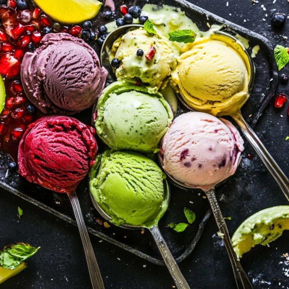 Close Up Of Scoops Of Unique Mexican Ice Cream Flavors Like Avocado, Hibiscus, And Tequila, Styled With Fresh Ingredients And Bold Garnishes.